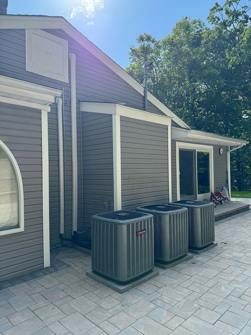 A house with a lot of air conditioners on the side of it.