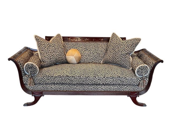 Ornate patterned sofa with two matching pillows and a beige cushion on a white background