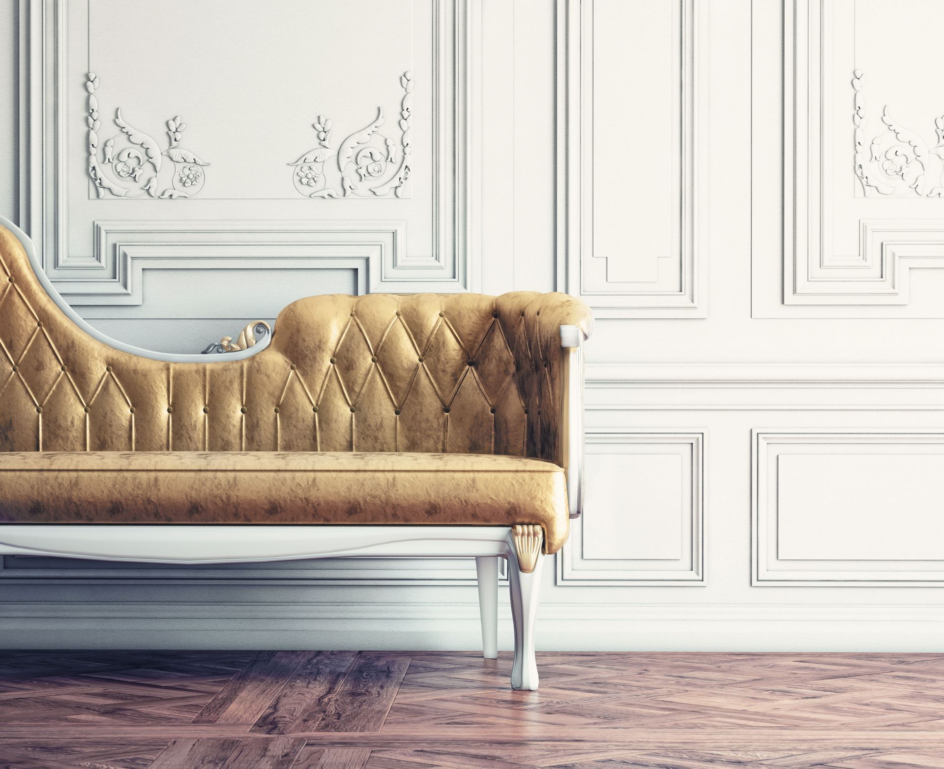 Gold tufted sofa against elegant white paneled wall in a bright room