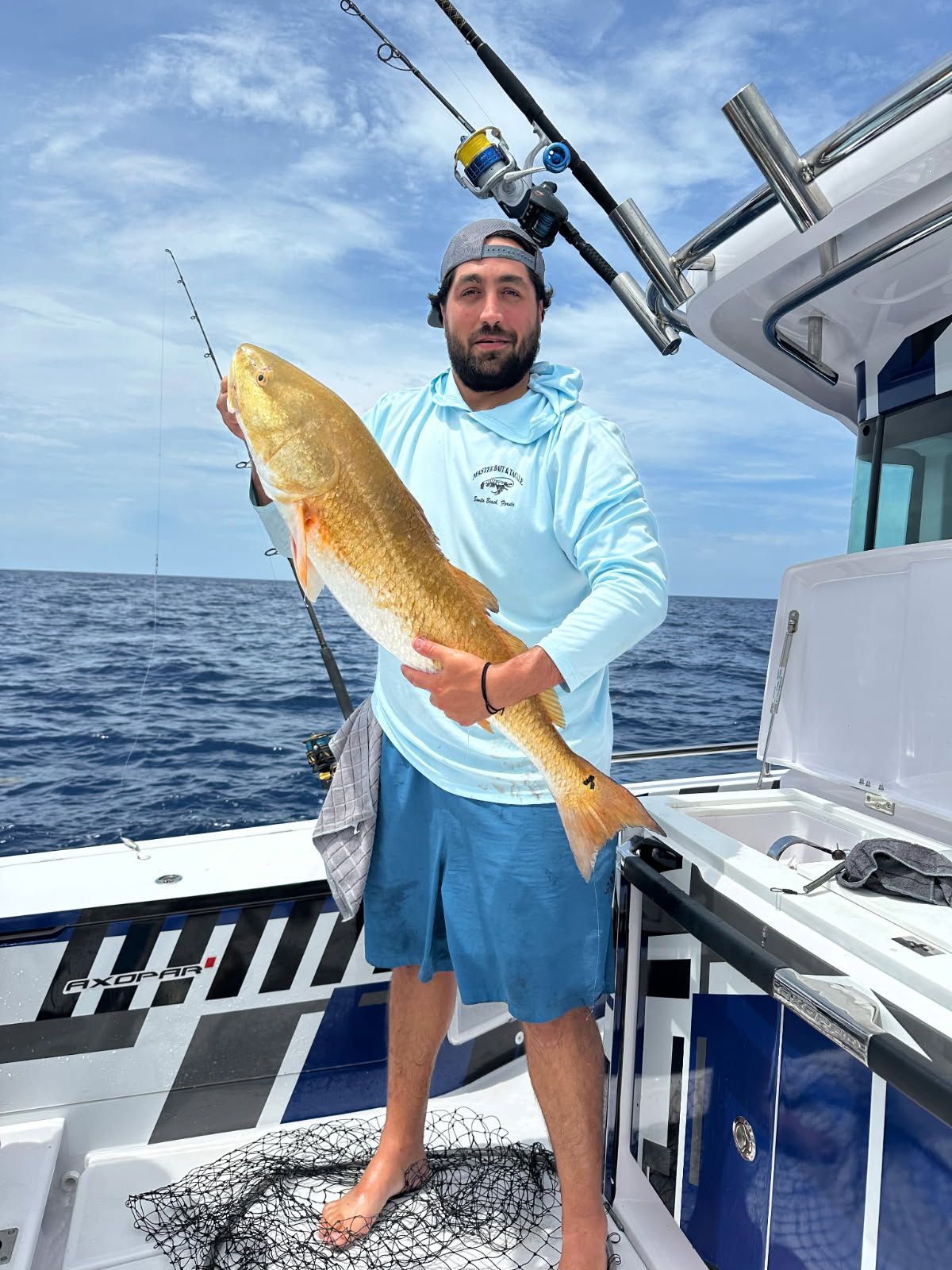 A man is holding a large fish on a boat.