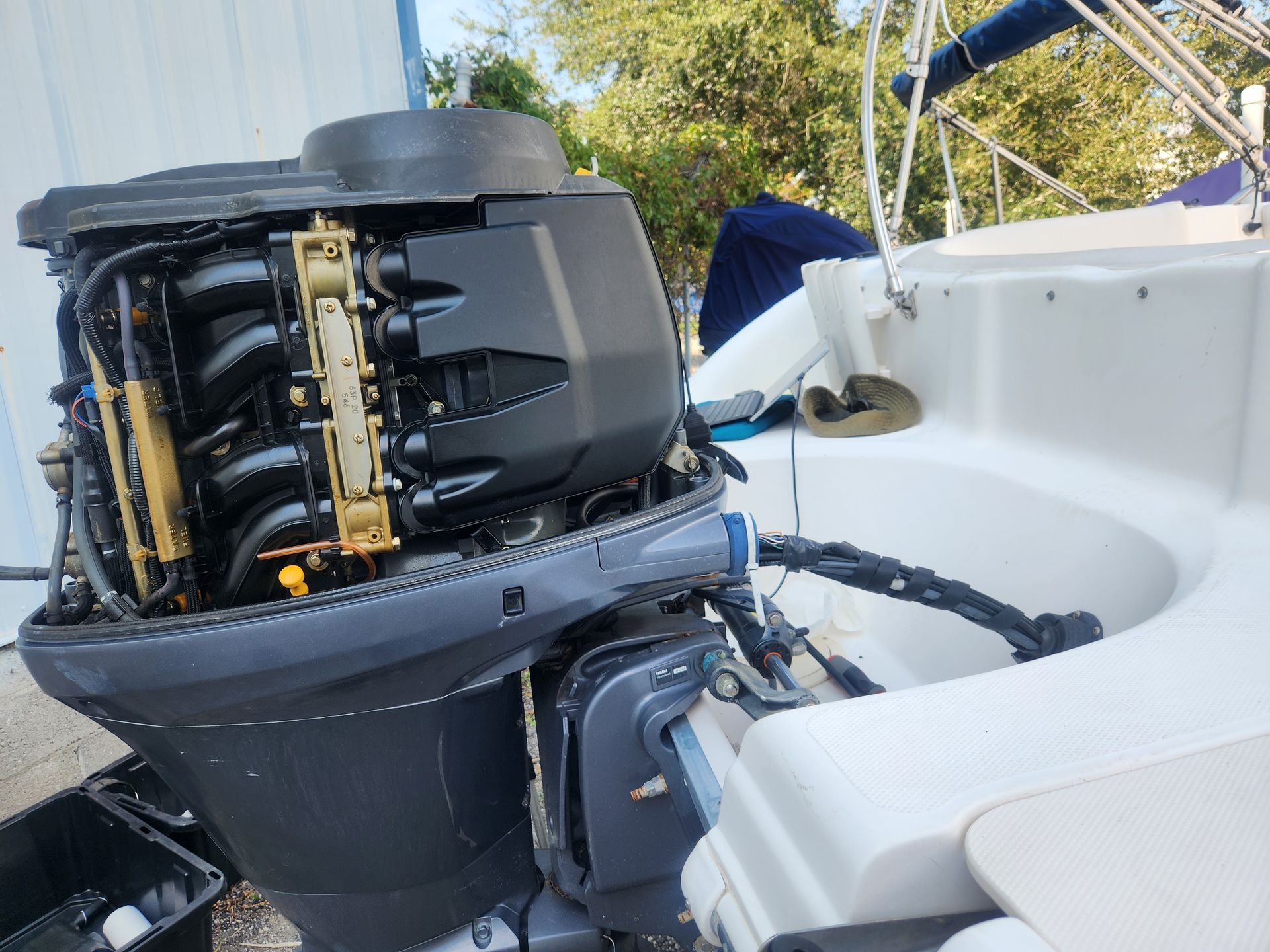 A boat engine is sitting on the side of a boat.