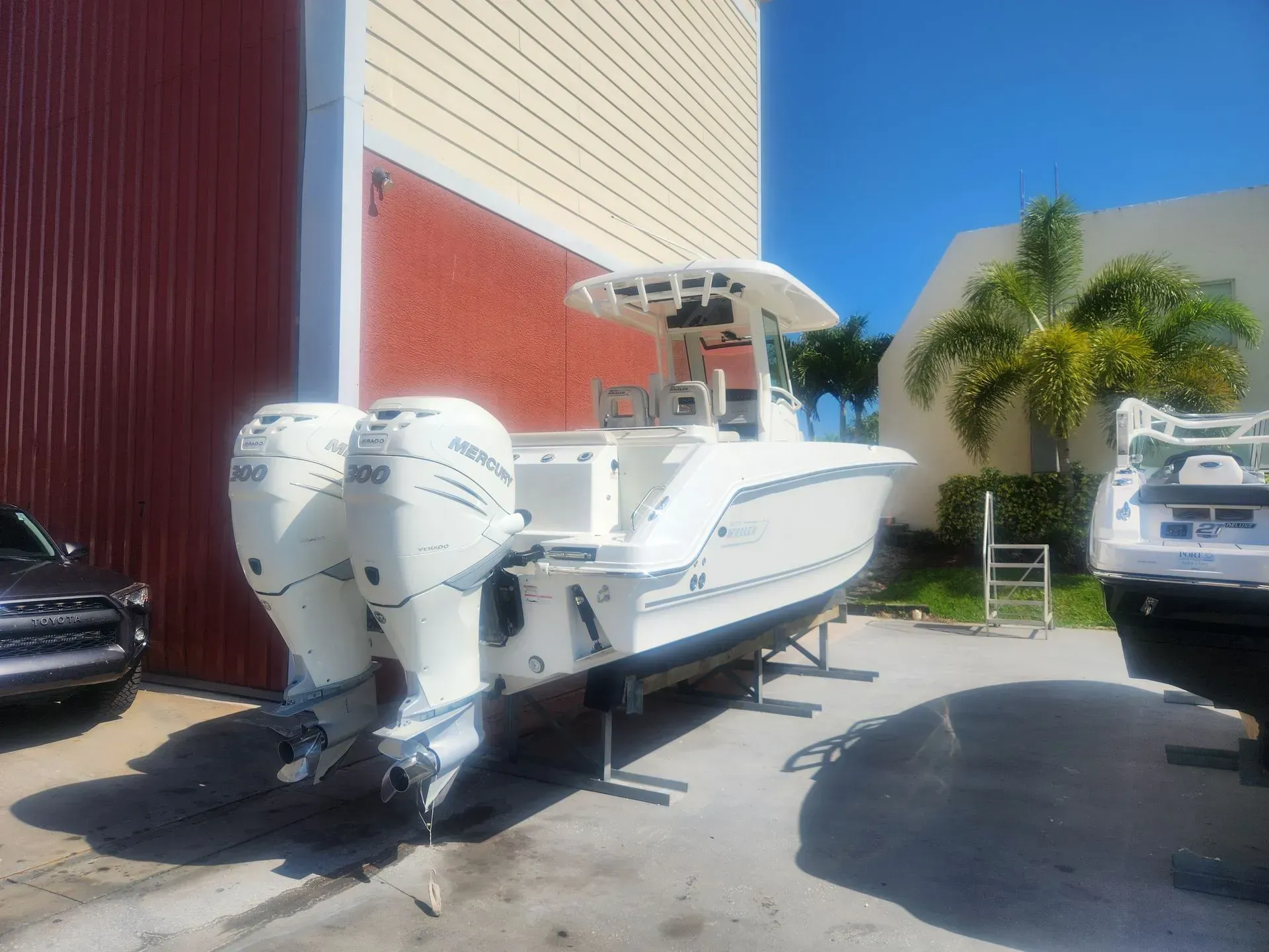 A white boat is parked in front of a building.