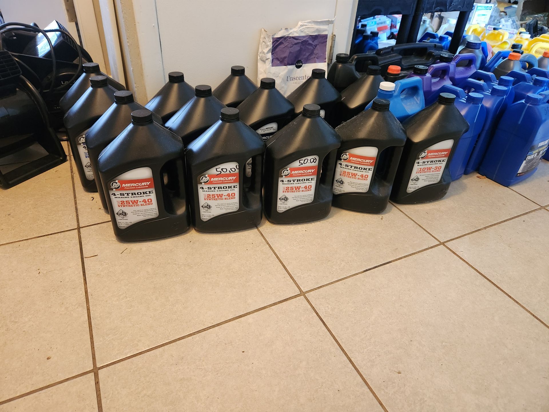 A bunch of bottles of oil are lined up on a tiled floor