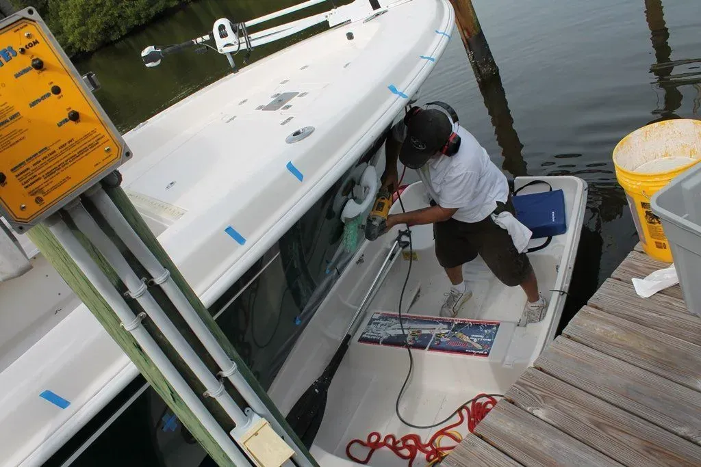 A man is working on a boat next to a yellow sign.