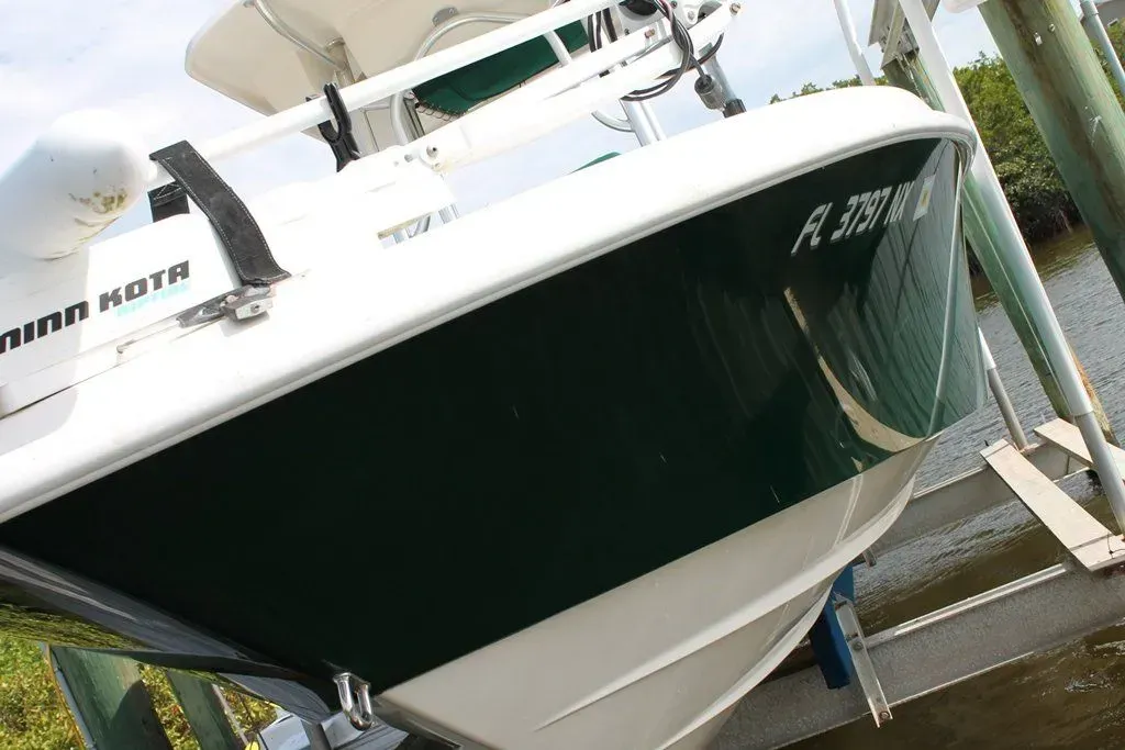 A green and white boat with a license plate.