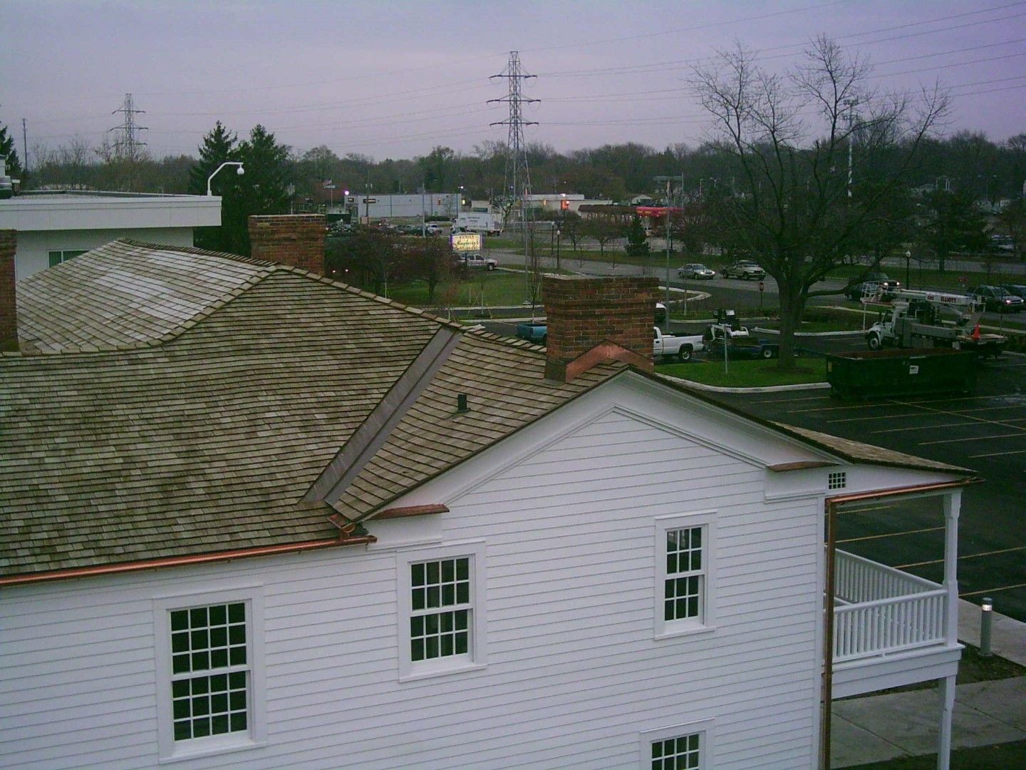 White house roof and porch in suburban neighborhood under overcast sky