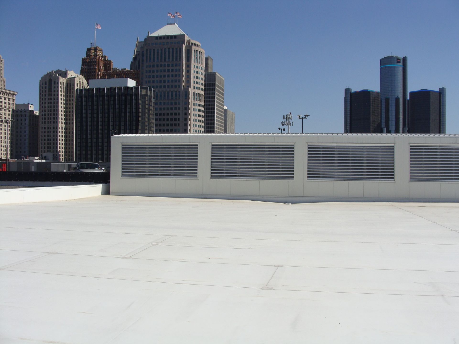 City skyline viewed from a white rooftop with vents in the foreground.