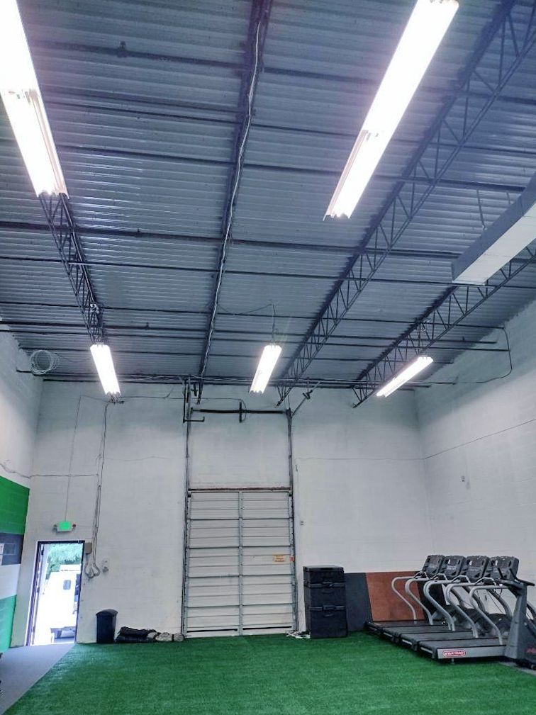 A gym with treadmills and a green wall.