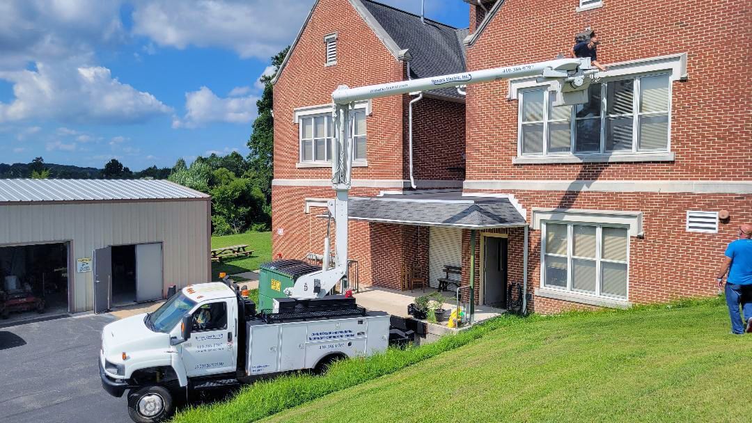 A white truck is parked in front of a large brick building.