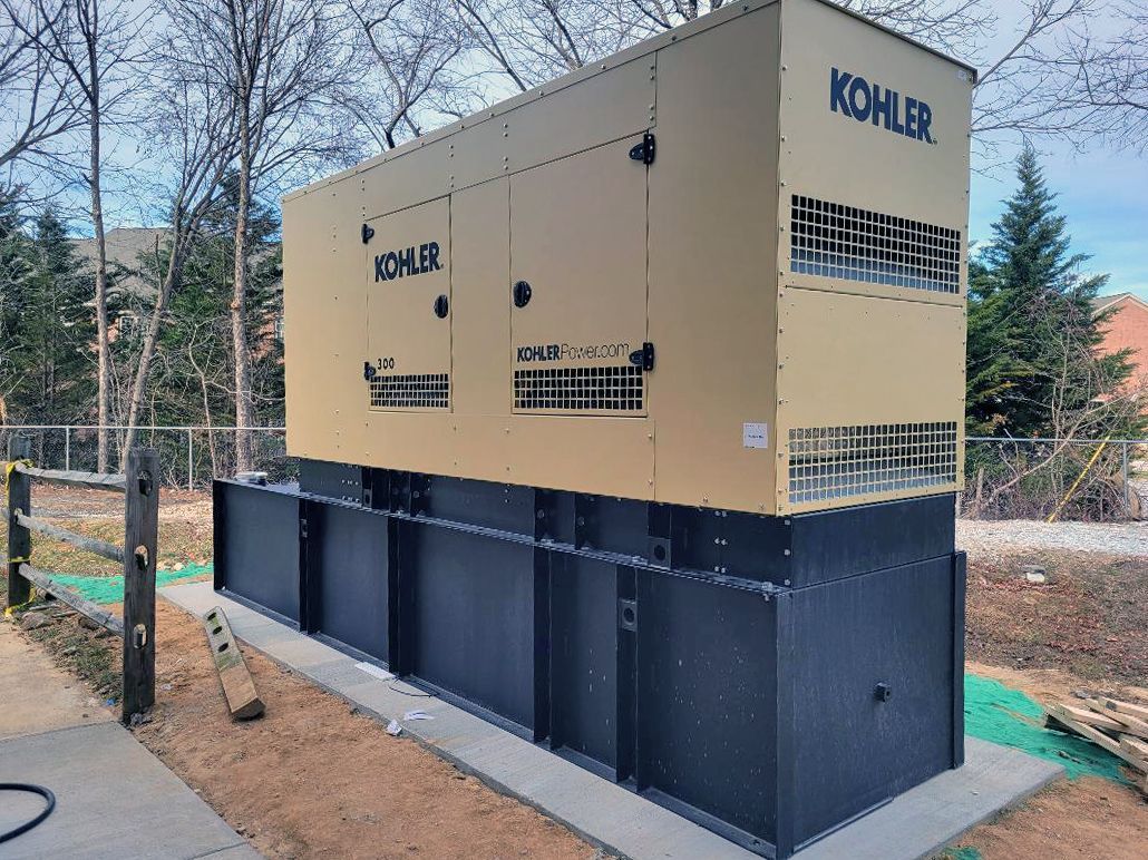 A large kohler generator is sitting on top of a concrete platform.