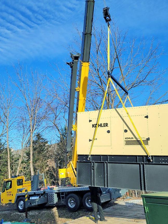 A crane is lifting a large box on top of a truck.