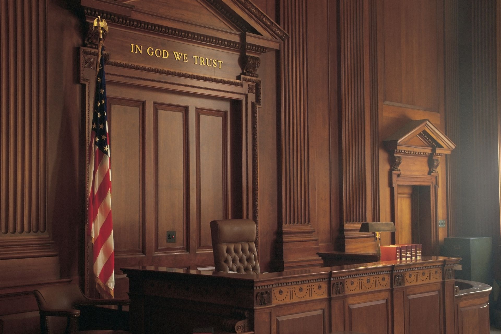 Wooden courtroom interior with American flag, judge's bench, and 