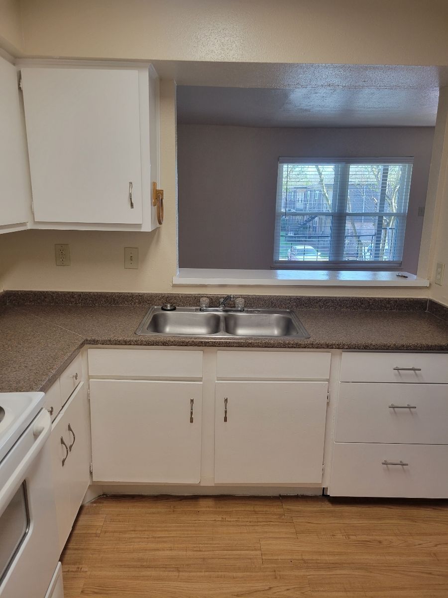 A kitchen with two sinks and white cabinets