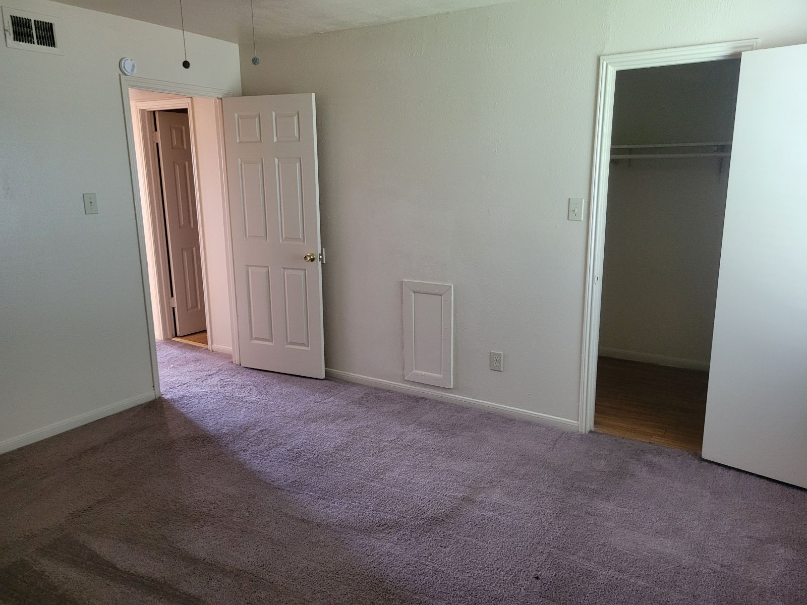 An empty room with carpeted floor