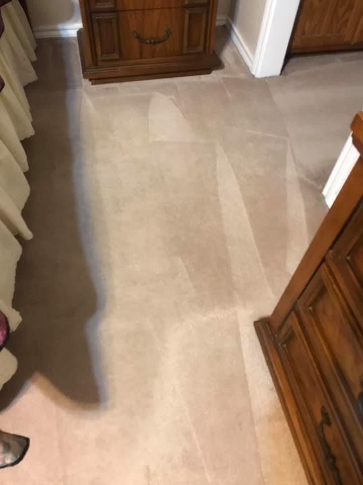 A person is standing on a carpeted floor in a bedroom.