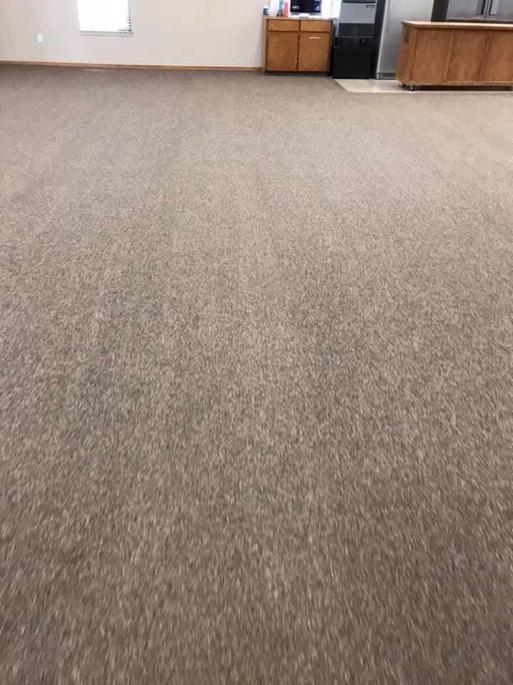 A large room with a carpeted floor and a wooden counter.