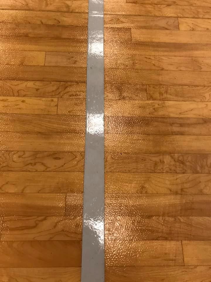 A wooden floor with a white line on it.