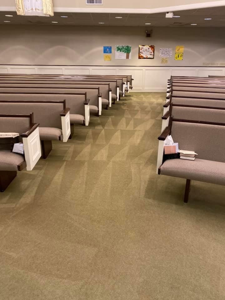 A church auditorium with rows of seats and a carpeted floor