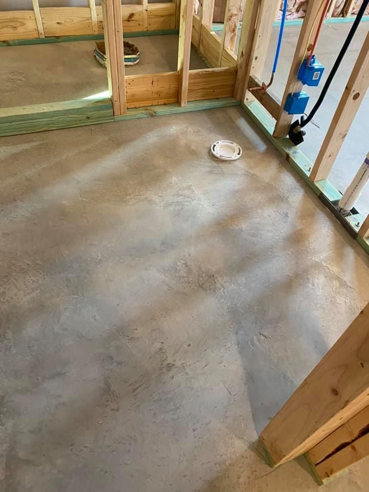 A concrete floor in a room under construction.