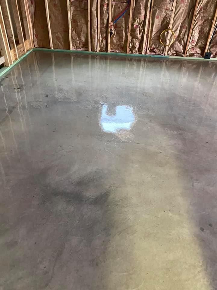 A room with a concrete floor and a window in the wall.