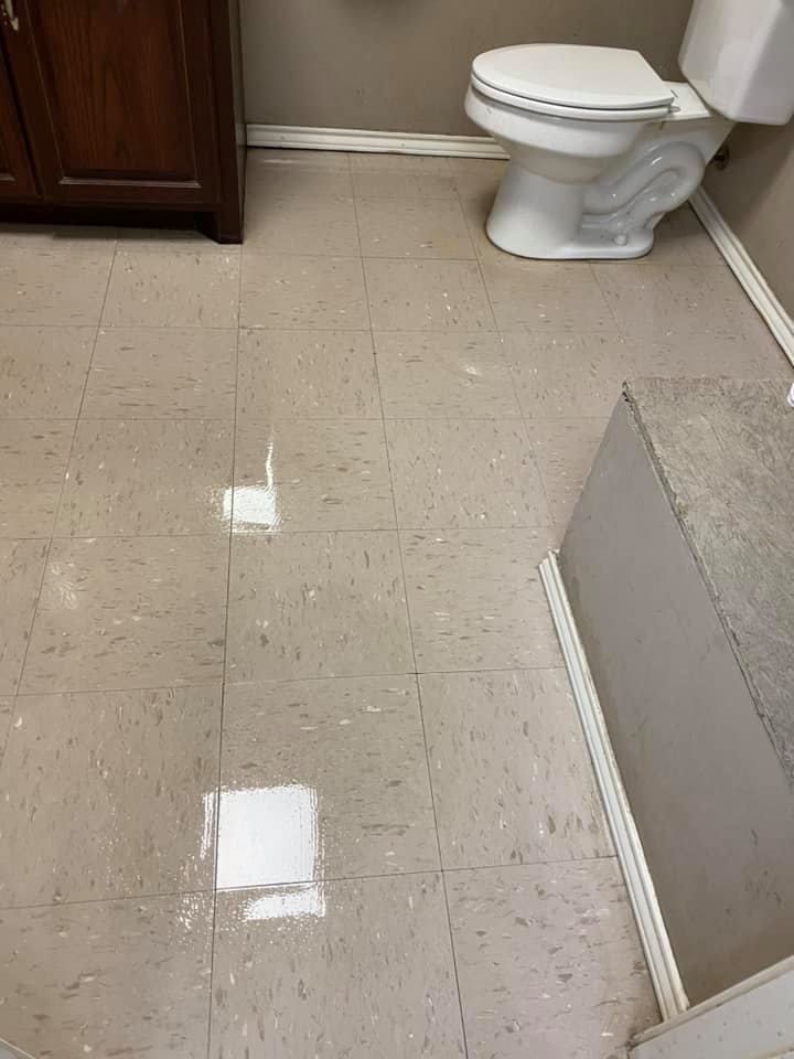 A bathroom with a toilet , sink and mirror.