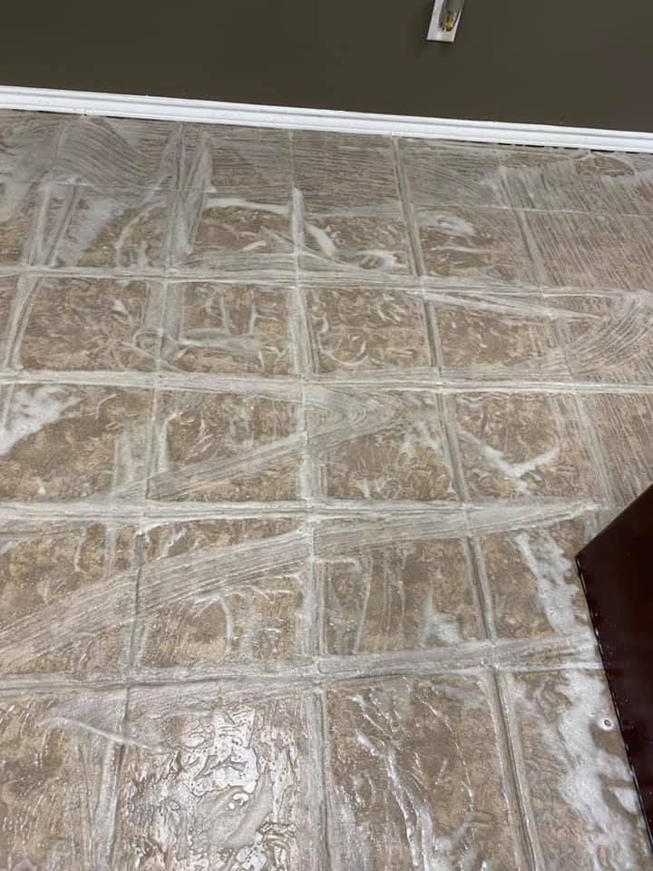 A tile floor with a lot of soap on it.
