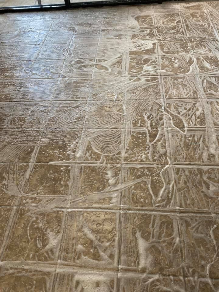 A tile floor with a lot of soap on it.
