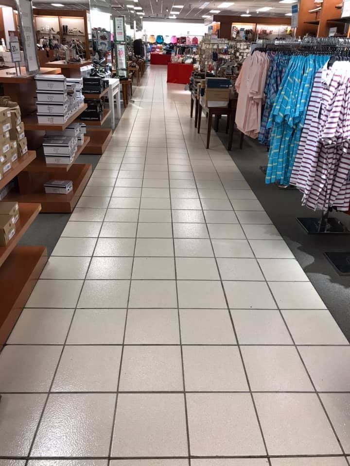 A tiled floor in a store with clothes on display