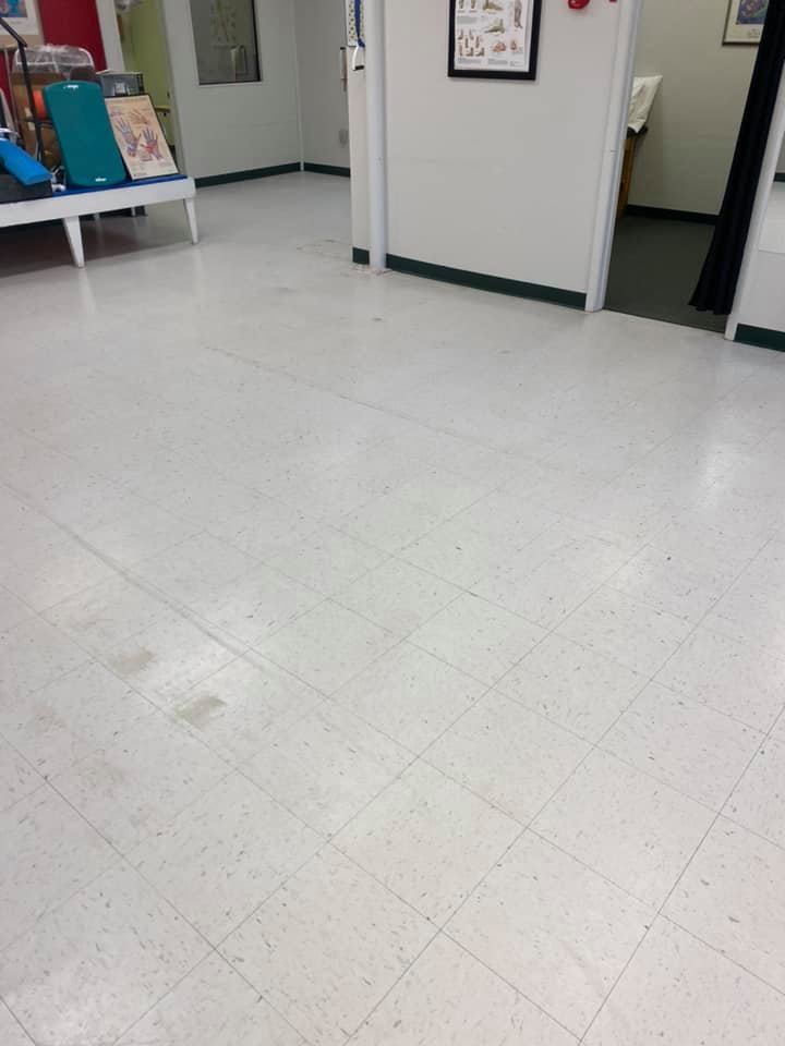 A white tiled floor in a room with a picture on the wall.