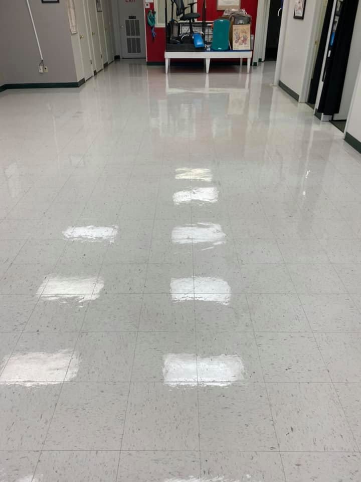 A large room with a white tile floor and a row of lights on the floor.