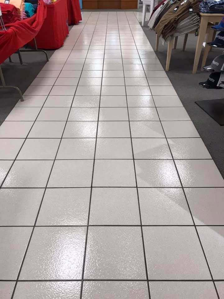 A long white tiled hallway in a store