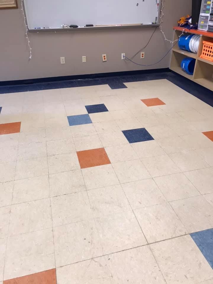 A classroom with a tiled floor and a white board