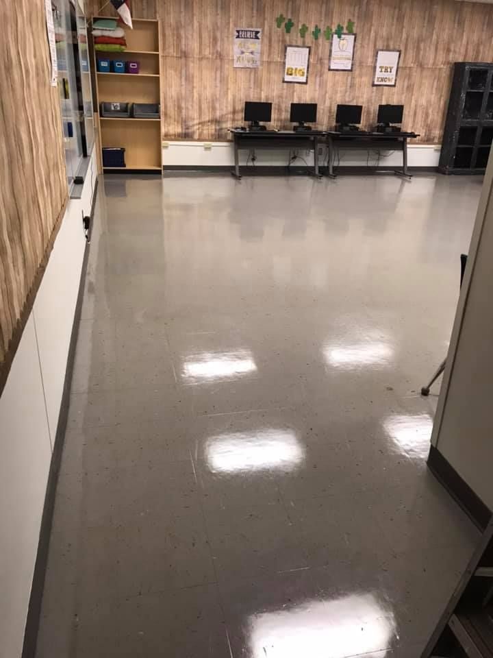 A hallway in a classroom with computers on the desks.