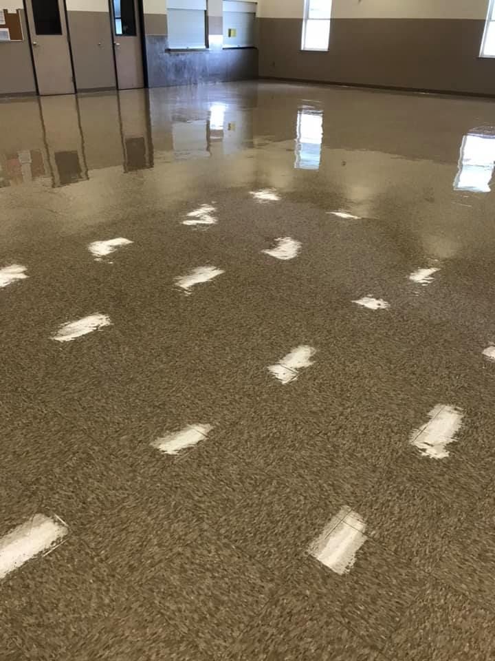 A room with a shiny floor and white arrows on it.