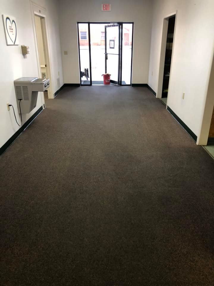 An empty room with a brown carpet and white walls.