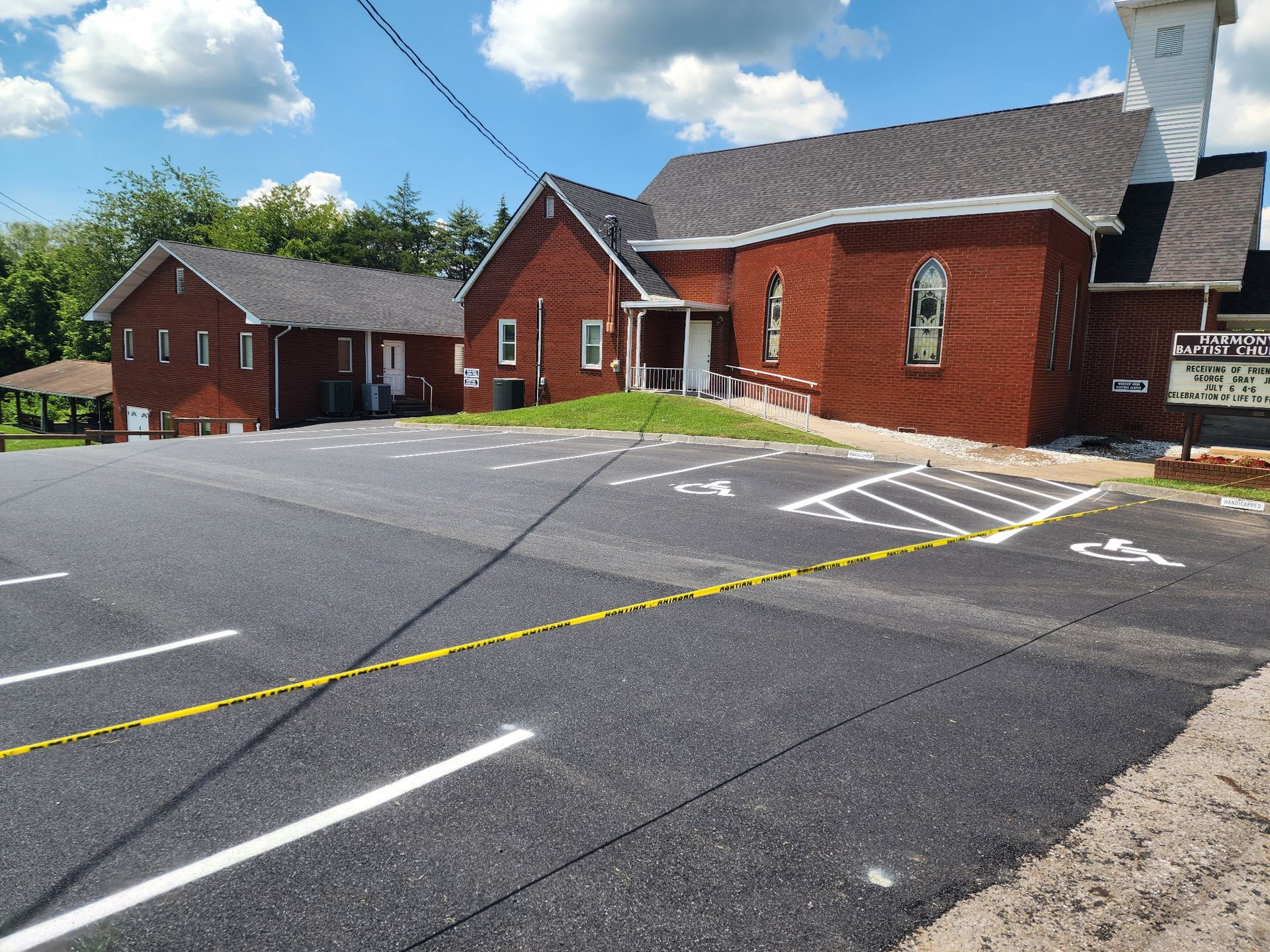 Church building with a brick exterior and a parking lot with handicap parking spaces.