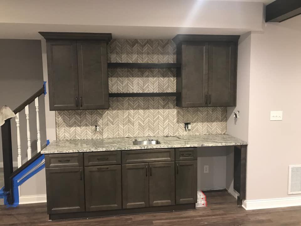 A kitchen with a sink and cabinets in a basement.