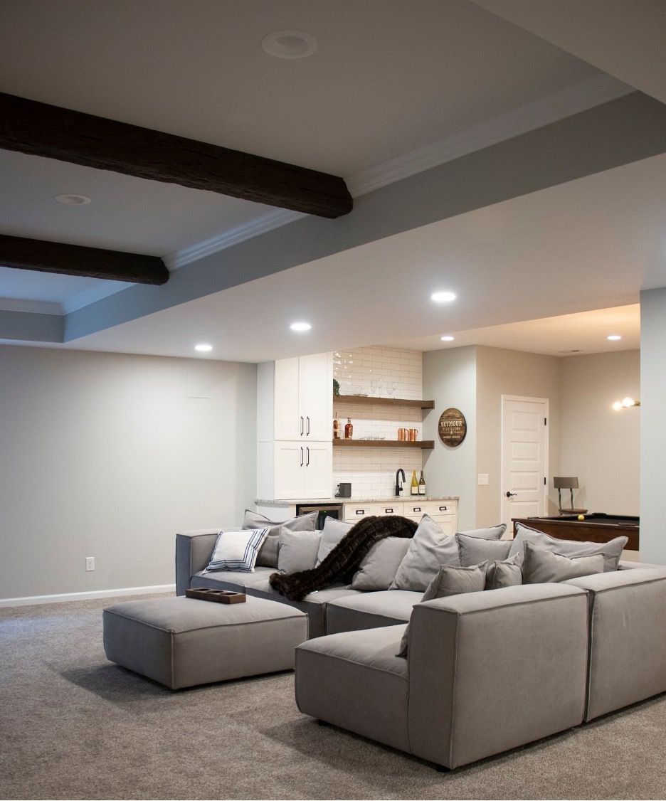 A basement living room with a lot of furniture and a pool table.