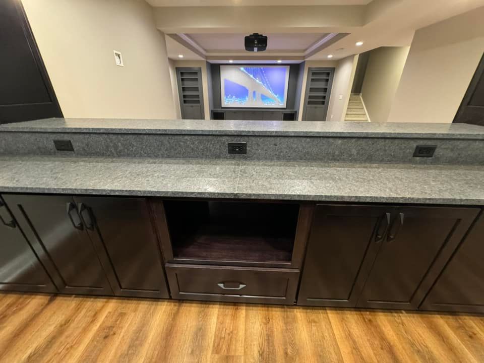 A kitchen counter with a projector screen in the background