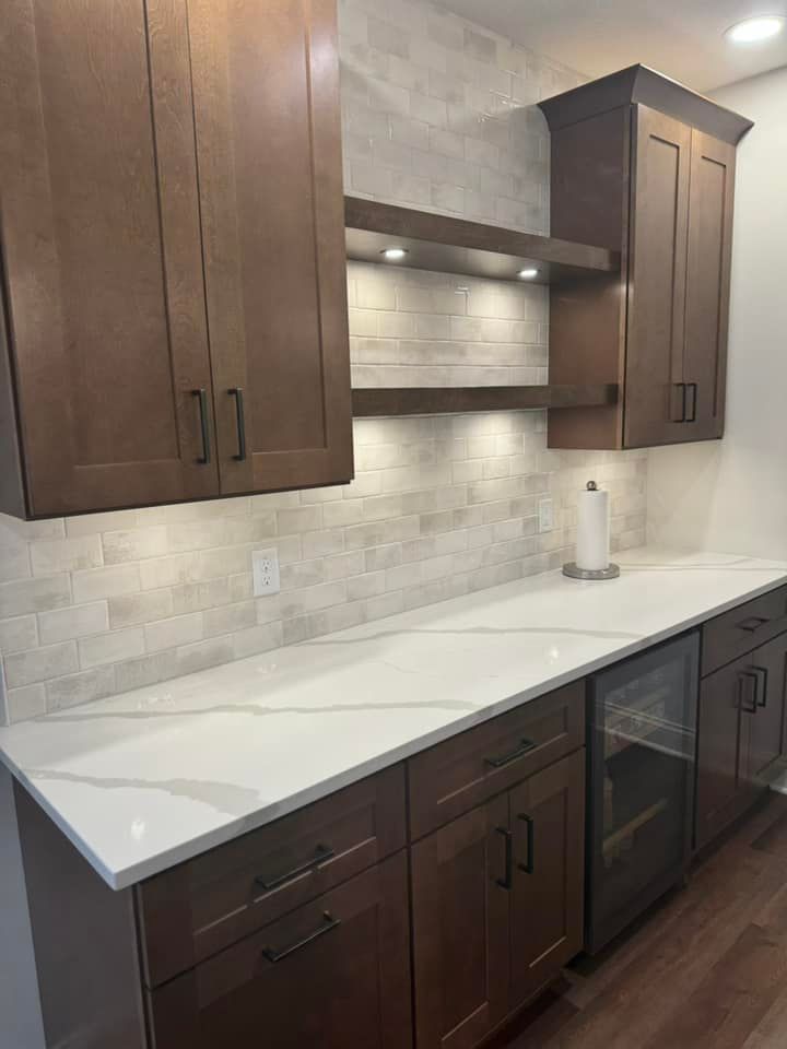 A kitchen with wooden cabinets and white counter tops