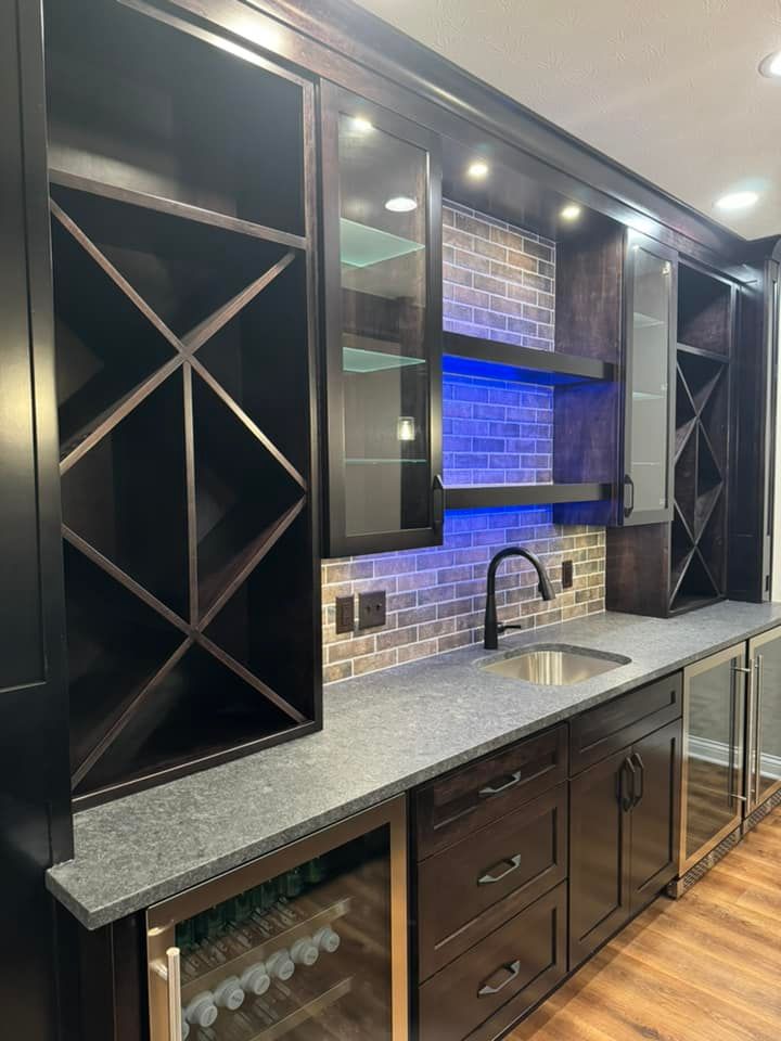 A kitchen with a sink, refrigerator, and wine racks