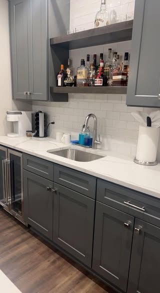 A kitchen with gray cabinets and white countertop