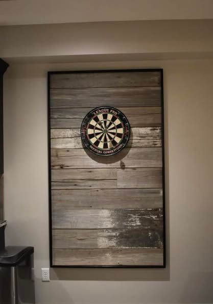 A dart board is hanging on a wooden wall