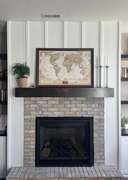 A fireplace with a map of the world on the mantle