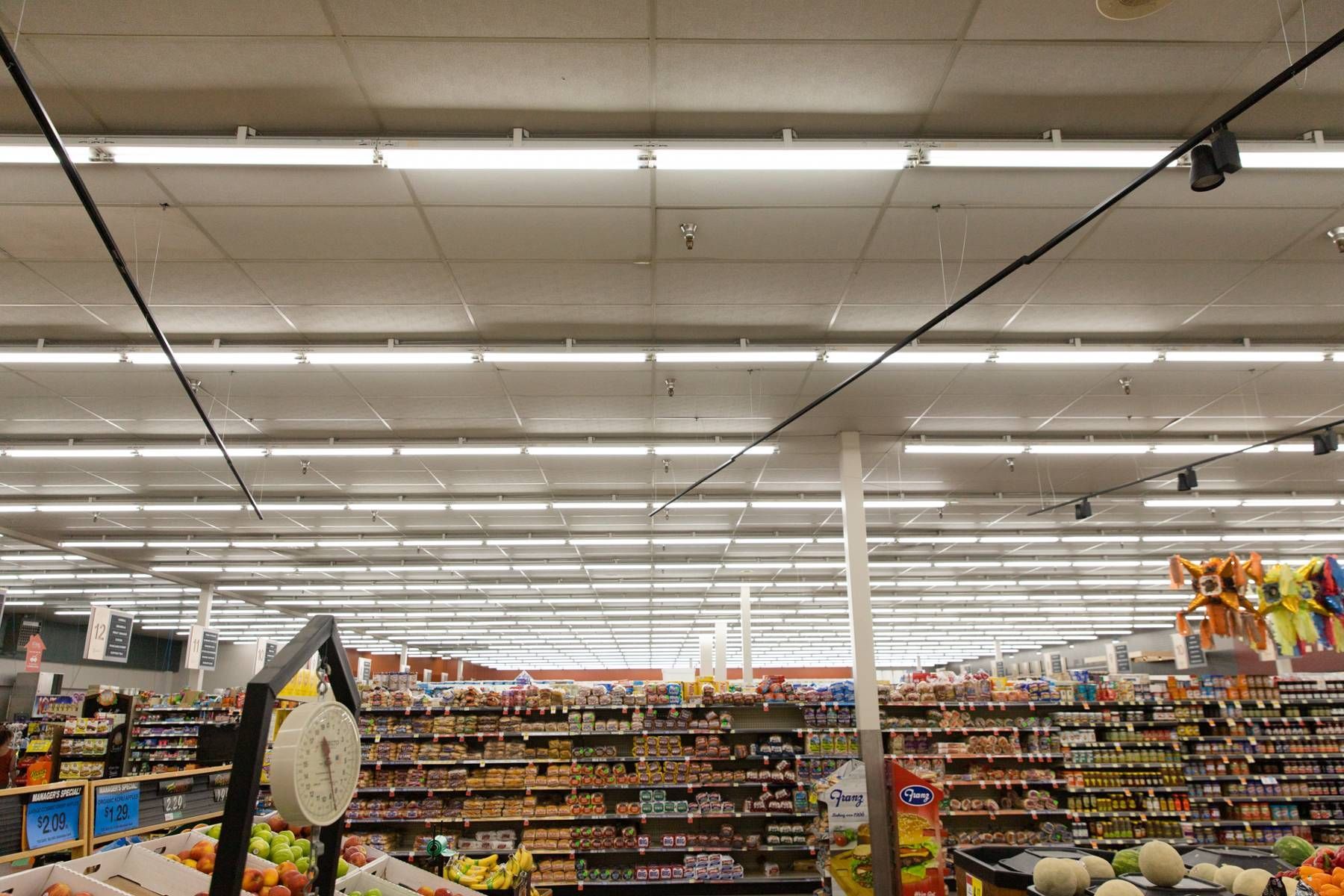 A grocery store with a scale in the middle of the aisle.