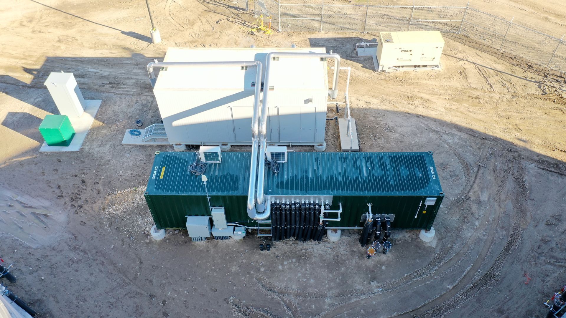 An aerial view of a large building in the middle of a dirt field.