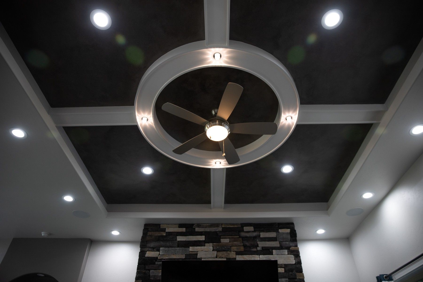 A ceiling fan is hanging from the ceiling of a living room.