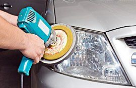 Car headlights with power buffer machine at service station