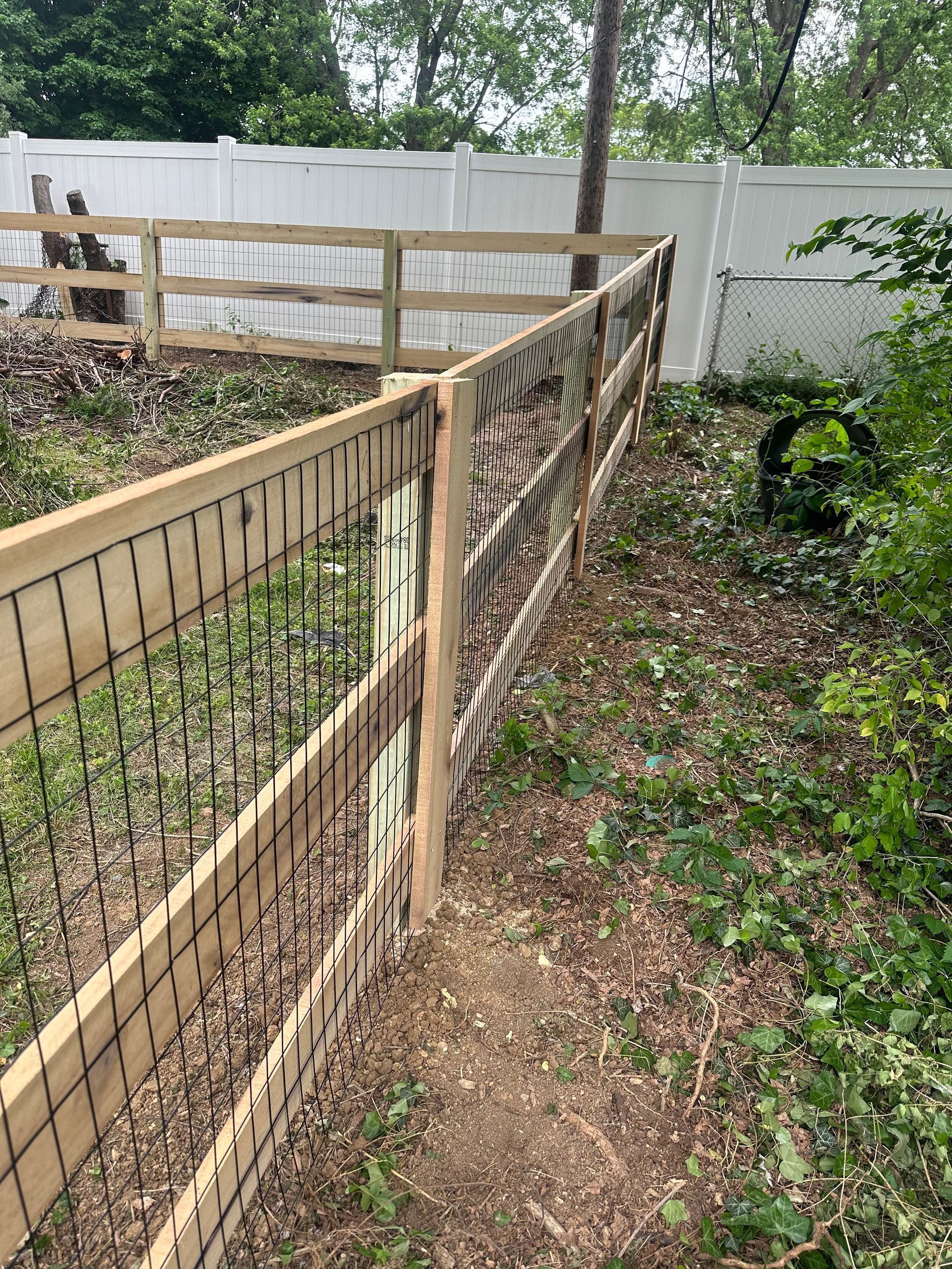 Wooden fence with wire mesh and decorative carved wood panels.