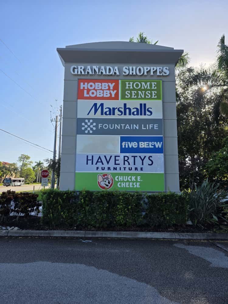 A pylon sign for Granada Shoppes listing stores including Hobby Lobby, Home Sense, Marshalls, Fountain Life, and others.